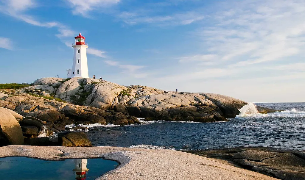 Faro blanco con cúpula roja situado sobre rocas frente al mar, iluminado por luz natural al atardecer, simbolizando orientación, estrategia y visión a largo plazo.