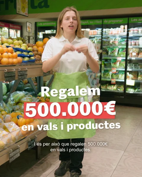Trabajadora de supermercado Sorli explicando una promoción entre frutas y refrigerados, con texto destacado sobre un sorteo de 500.000 € en vales y productos.