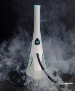 Shisha premium de diseño blanco minimalista rodeada de humo sobre fondo oscuro, destacando su silueta estilizada, iluminación suave y aspecto tecnológico propio de la marca.