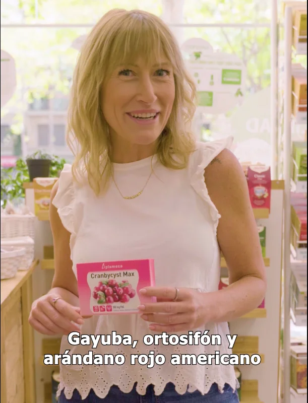 Mujer en tienda sujetando un producto de Plameca, rodeada de estanterías con complementos naturales, en una escena cálida que transmite cercanía, consumo real y comunicación orientada al retail.